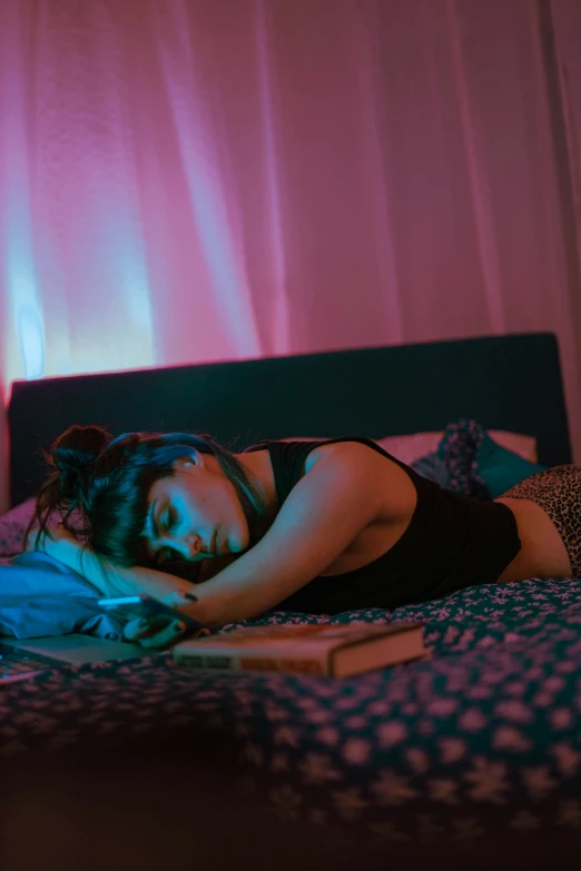 a young woman is asleep in her bed with a book