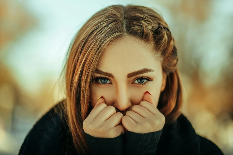 a close up of a person covering their face with hands