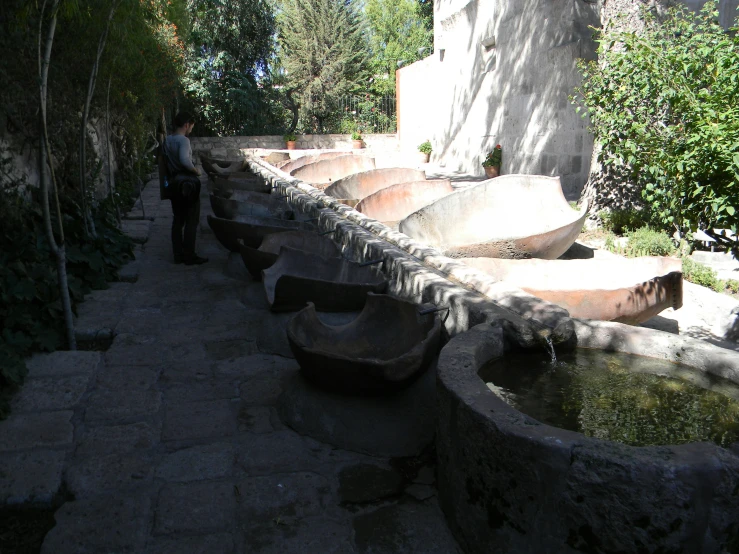 a row of cement boats are lined up along a narrow walkway