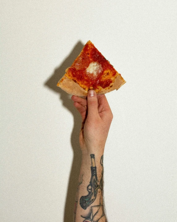 hand holding a half eaten slice of pizza