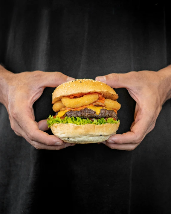 the burger is held in both hands