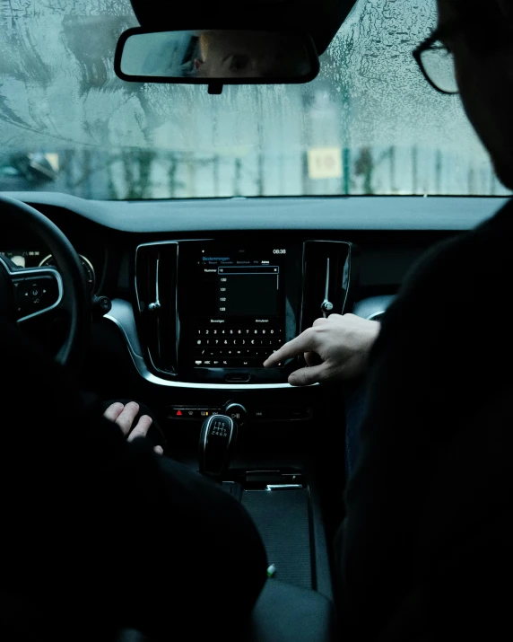 a man in the car holds a laptop computer