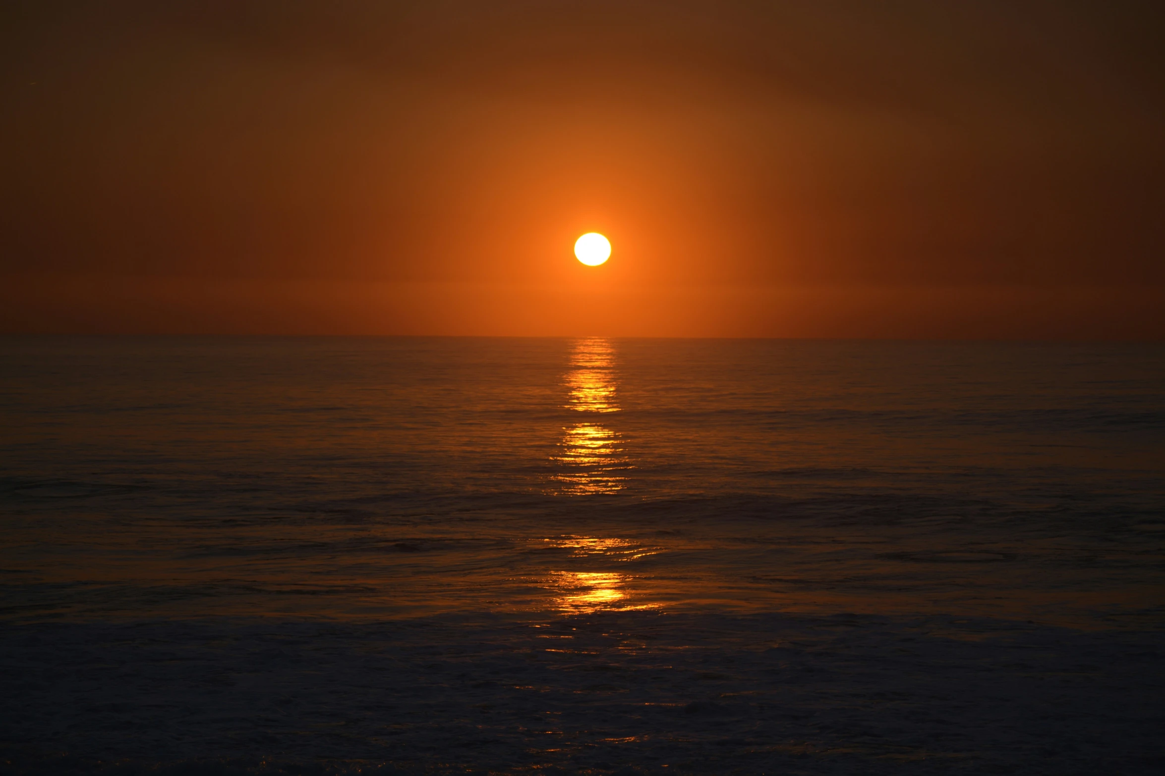 a sunset over the ocean that is mostly empty