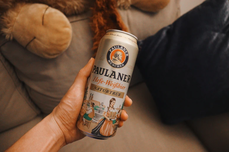 a woman holding a can of beer with an orange tail