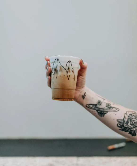 a man holds a cup in front of his face