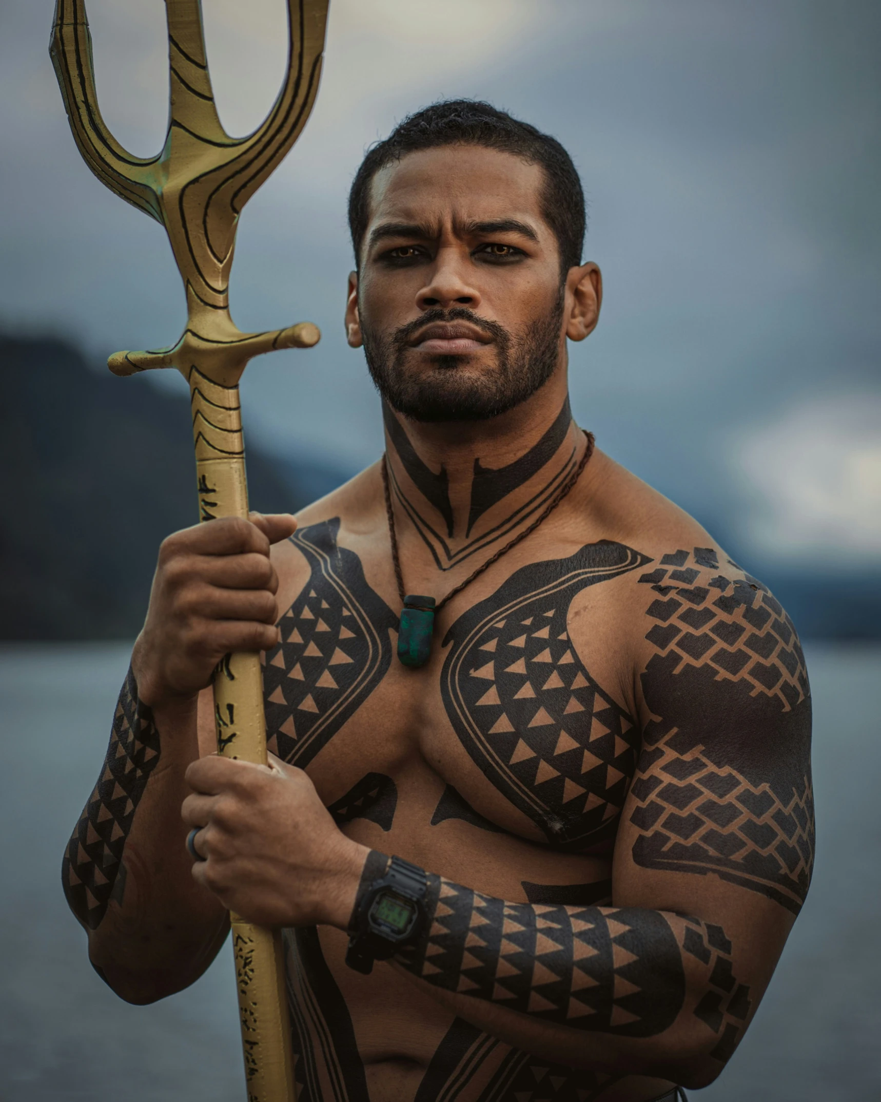 a man with a large tribal tattoo holding a metal pole