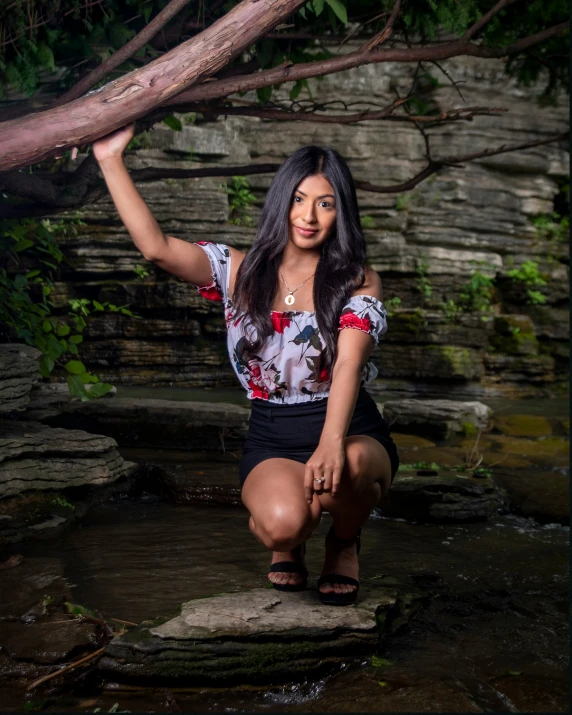 a woman sitting on some rocks in water