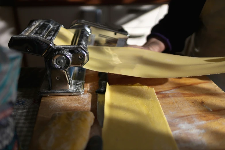 a close up of pasta being shredded on a pasta peeler