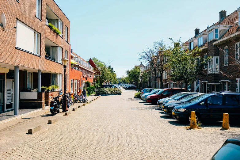 cars parked on a street with two motorcyclist and people