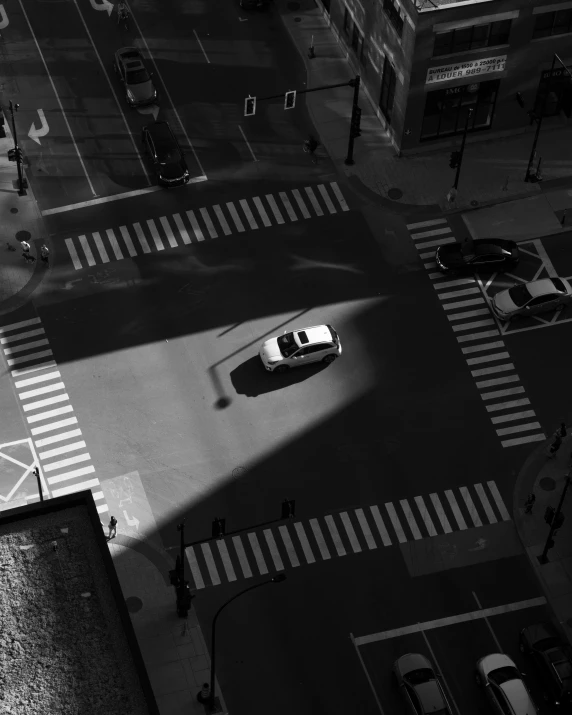 a black and white po of an intersection with a car on it