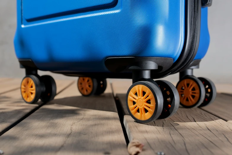 a blue suitcase is standing on the wood