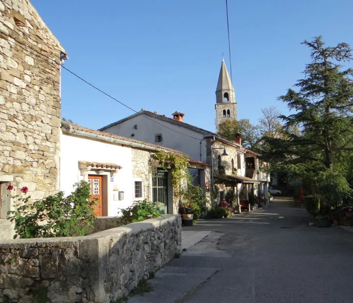 a clock tower standing over an older village street