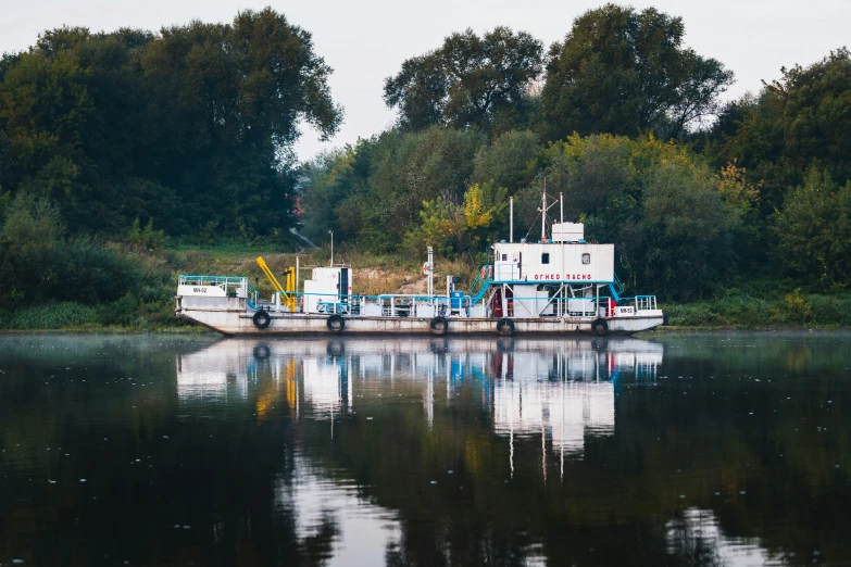 a ship on a river in a wooded area