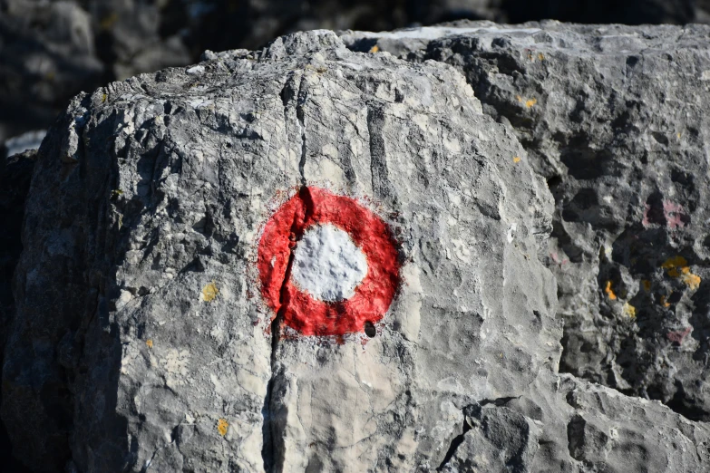 red circle shaped on rock next to gray granite