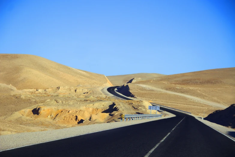 a very wide desert highway and some mountains