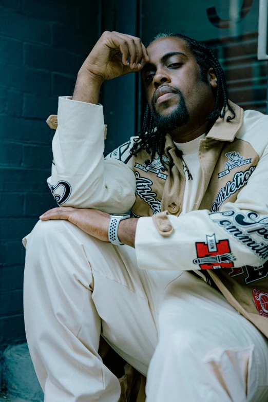 a black man sitting on the steps with his arms crossed