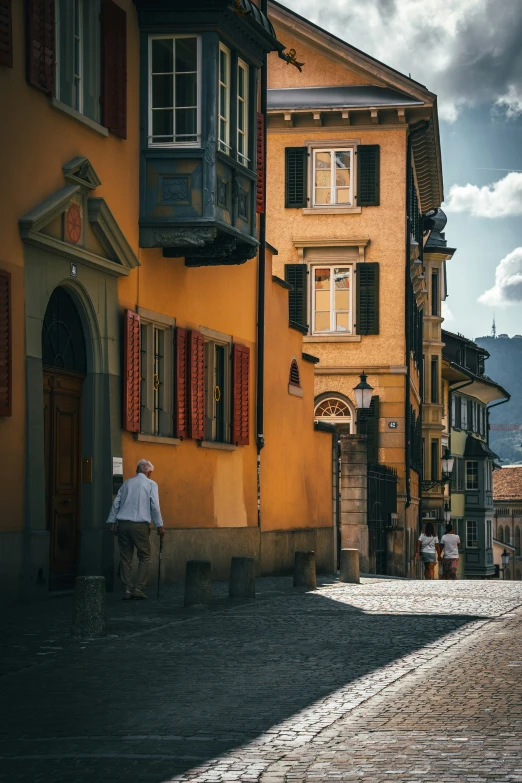 two men are walking up the side walk in front of two buildings