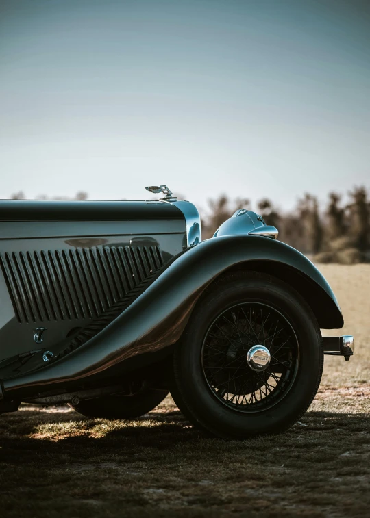 a silver car parked in front of a field