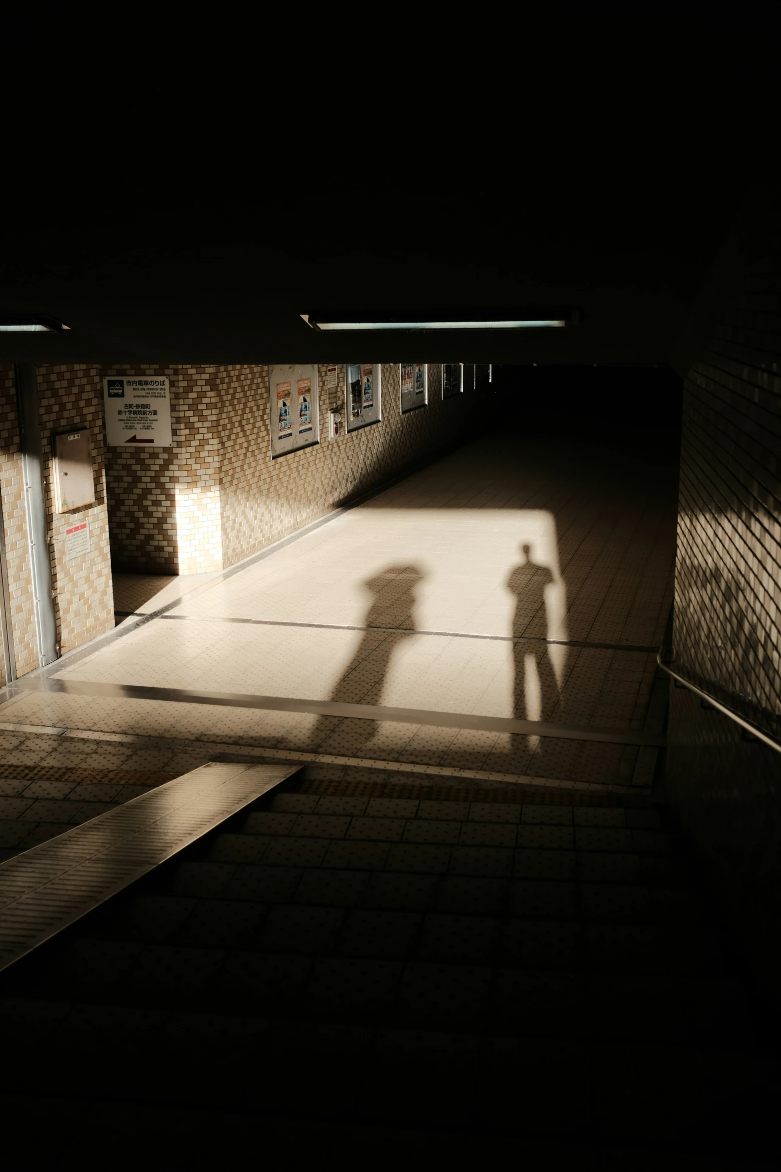 two people shadow on the ground under a light