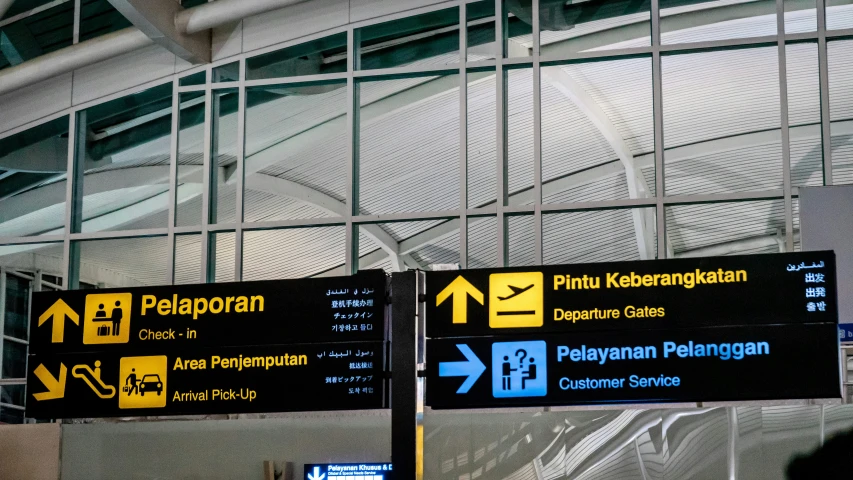 airport signs set up in the air by large meshed walls