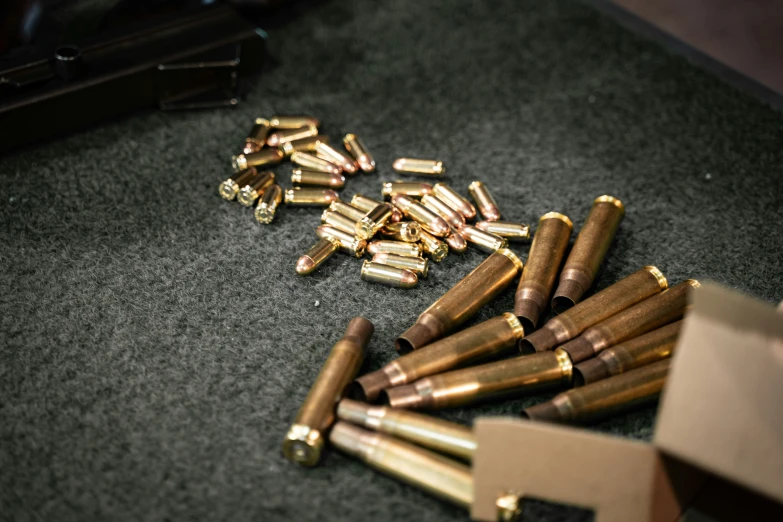 many ss bullet cartridges on the floor next to an open box