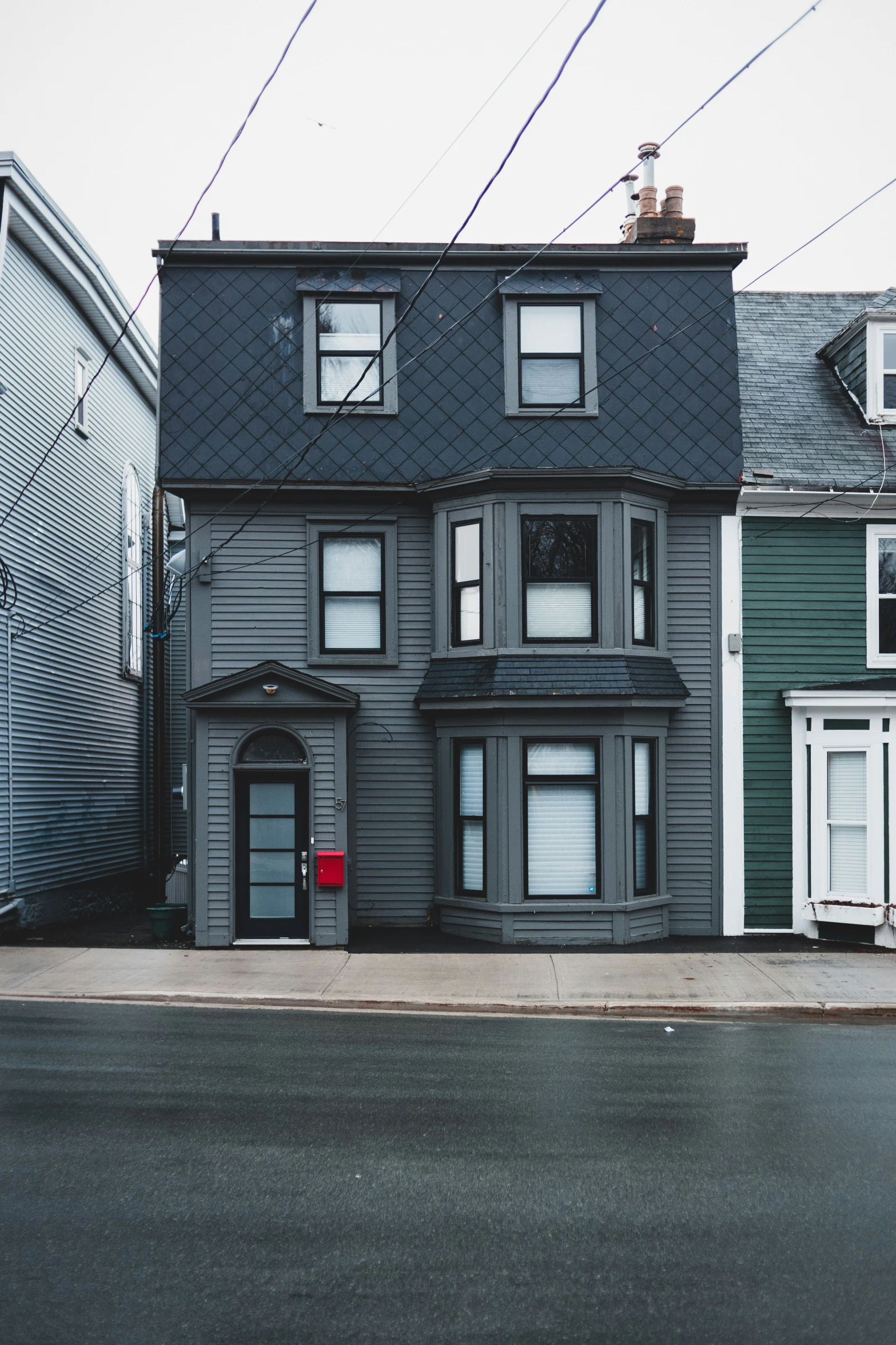 the gray two story house on a street corner