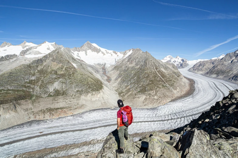 a person standing on top of a mountain with a very big glacier