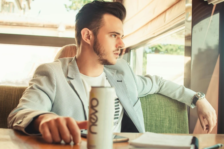 a man sitting at a table while using his computer