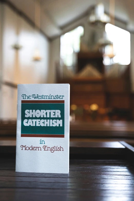 the westminster shortter catheish sign in front of a church pew