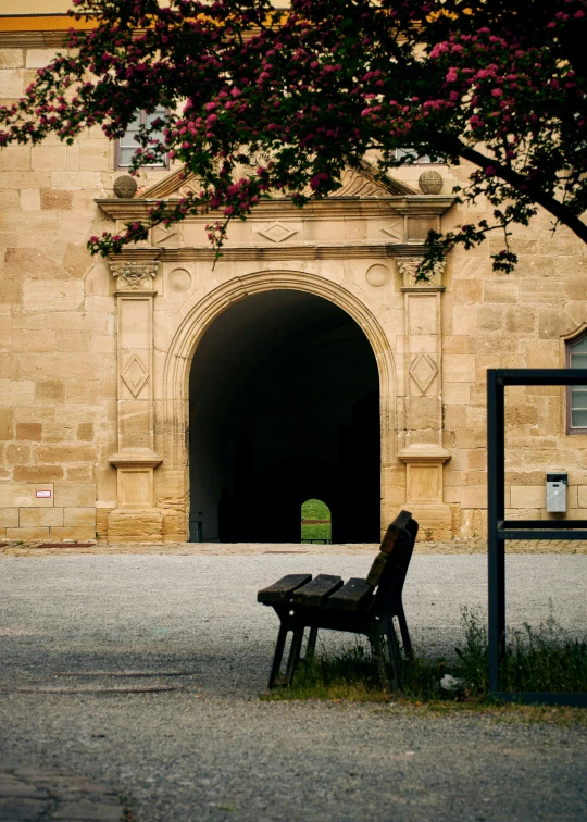 a lonely wooden bench in front of a building