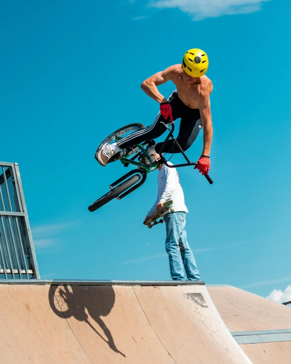 man with bicycle standing on a half pipe