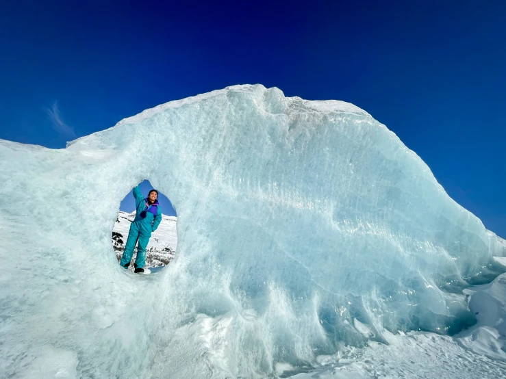 snowboarder standing by a large snow pile while skiing