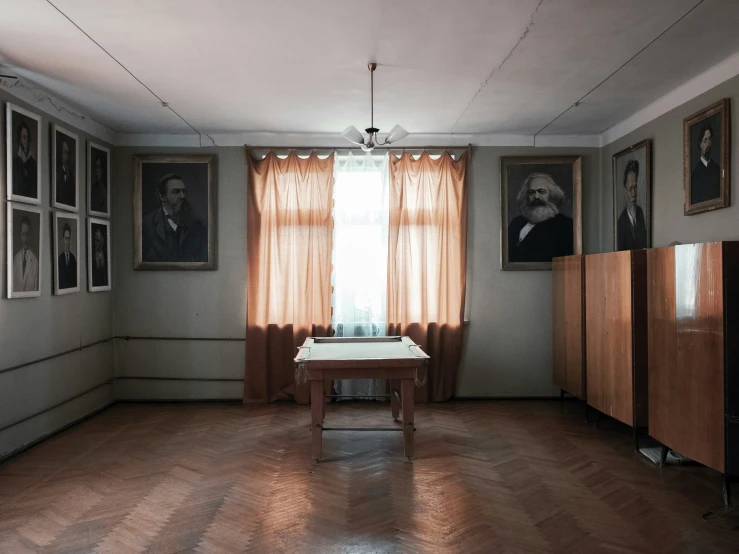 a room with pictures on the walls and a small wooden desk in the middle