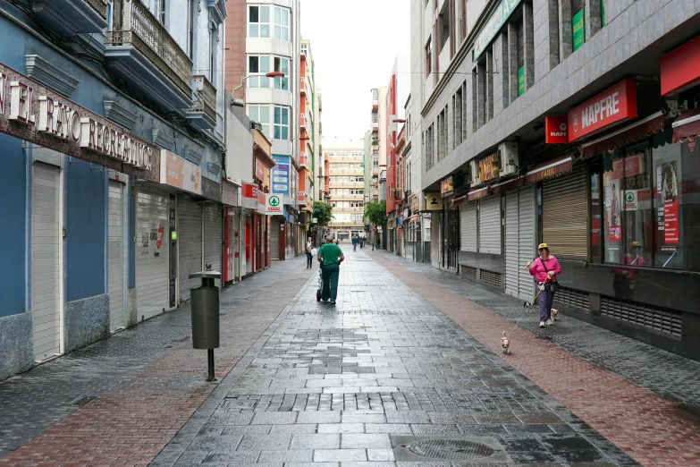 the couple is walking down the sidewalk in the street