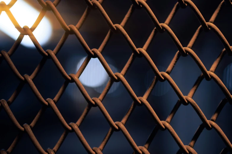 a close up of a metal fence with light