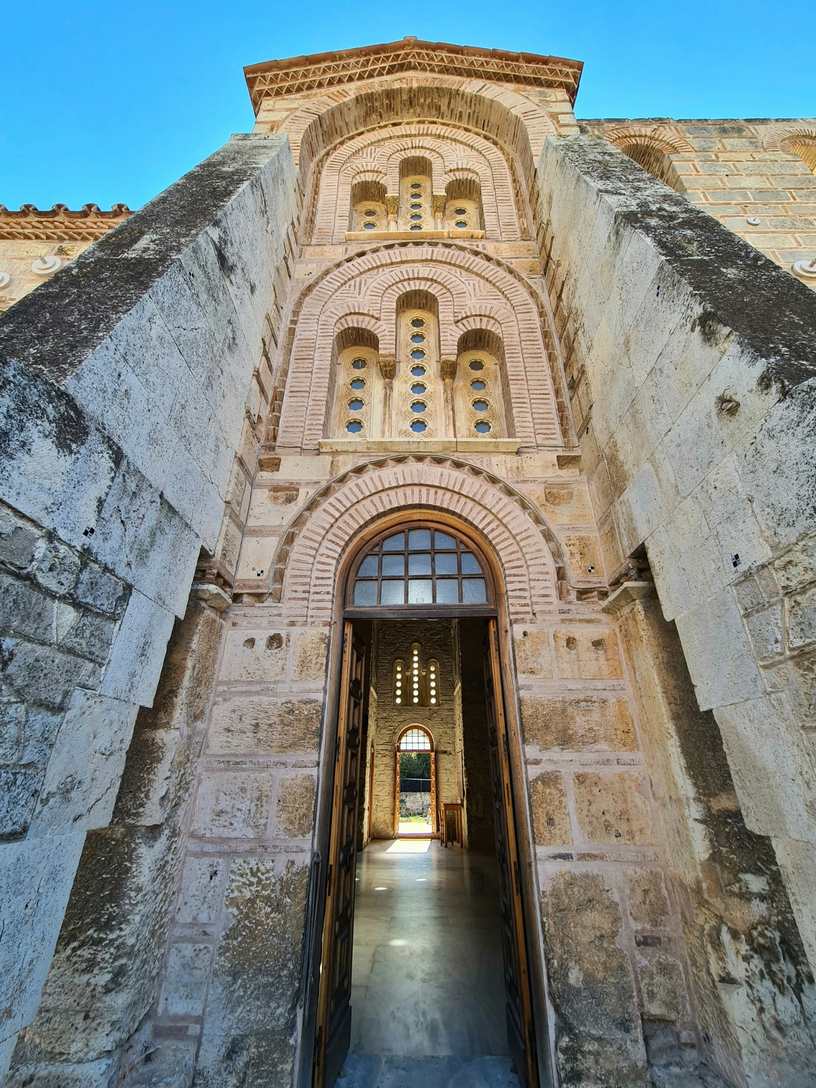 an entrance to a large building with some stone walls and an arched doorway