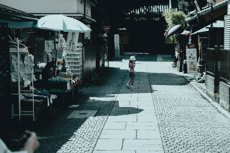 a little girl is walking through the street