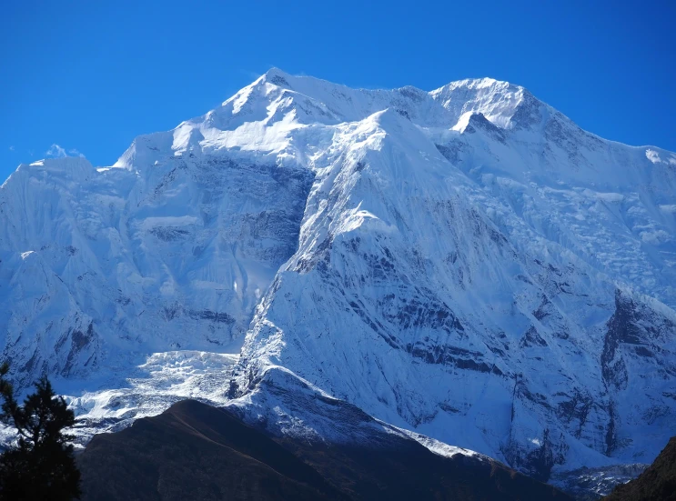 the mountains are covered in white snow against a blue sky