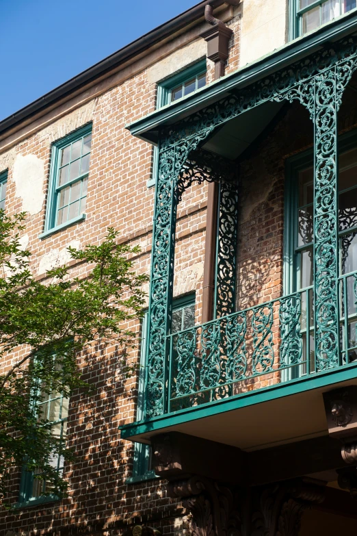 there is a metal balcony and green railing on the building