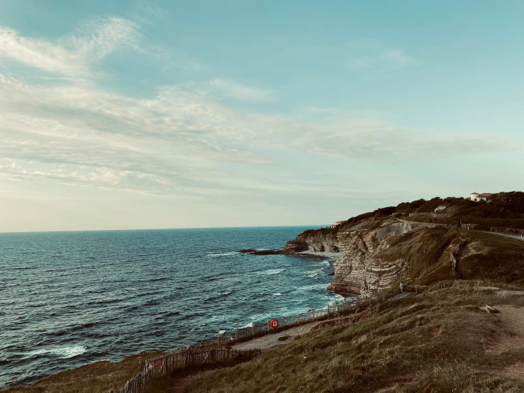 a lighthouse sitting on top of a cliff above the ocean