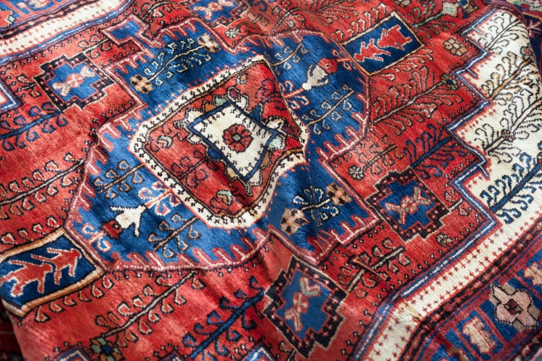 a red persian rug with an ornate design