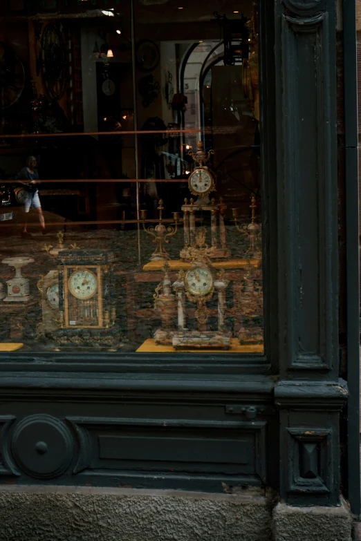 a clock storefront with decorative clocks behind glass