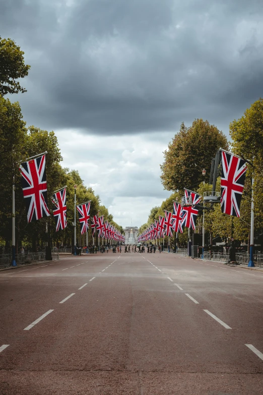 several british flags and flag posts stand on a deserted street