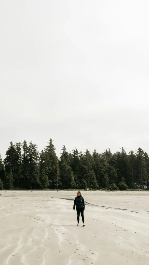 a person is walking in the sand while holding a parasail