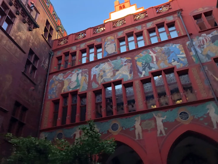 an orange building with colorful painting on the outside and windows