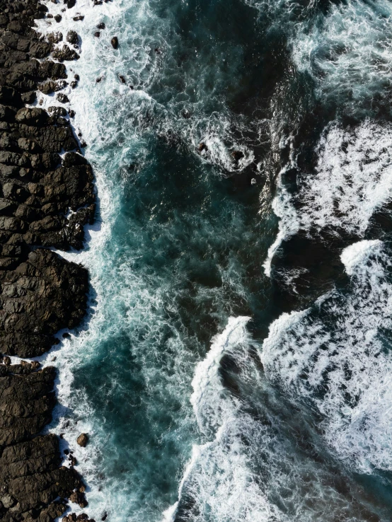 the water is very blue and the rocks are black