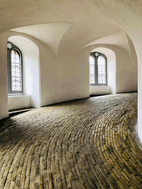 a brick floor has three windows and two arches