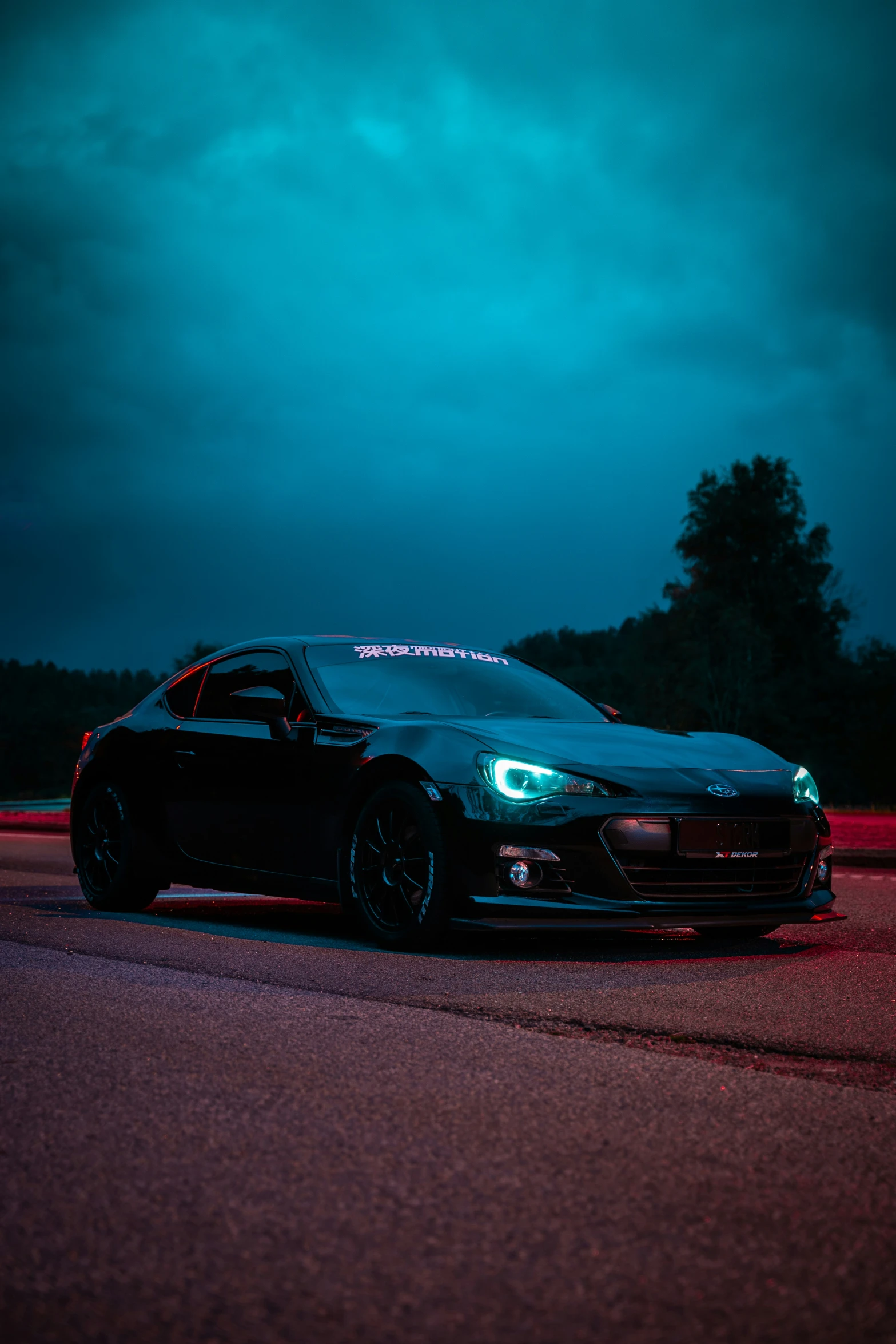 a sports car is parked in a parking lot at night