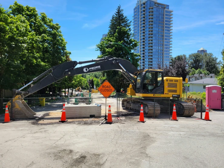 a yellow crane standing over some construction at the edge of a road