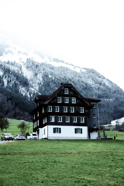 an old house in front of a snow - capped mountain